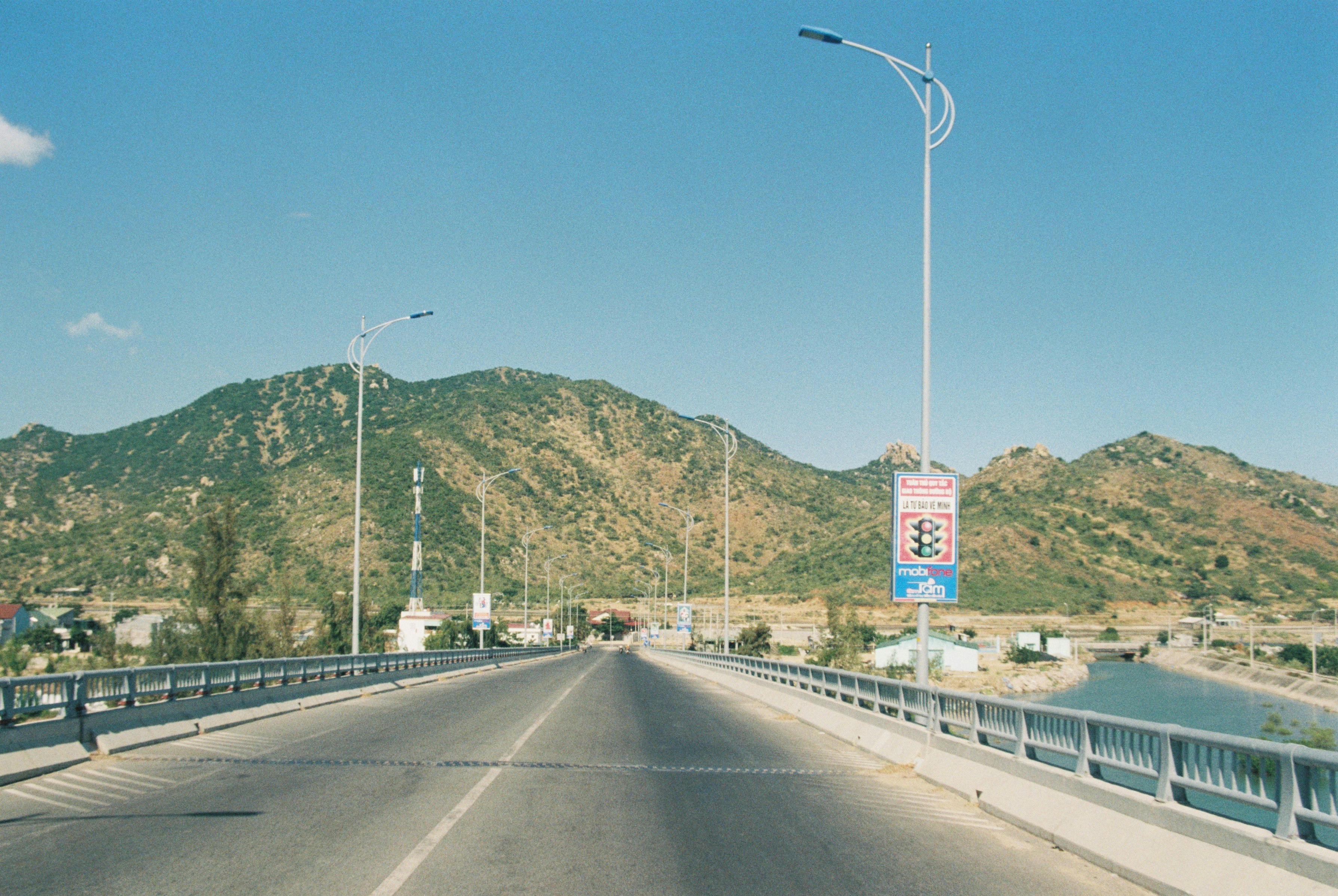 gray concrete road with white car on the side during daytime